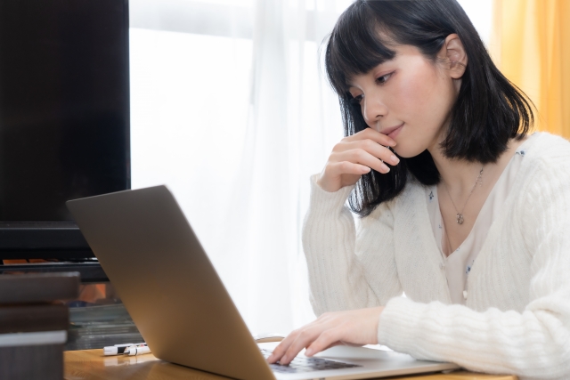 沼津市で前かがみの姿勢でパソコンを操作する女性のイメージ