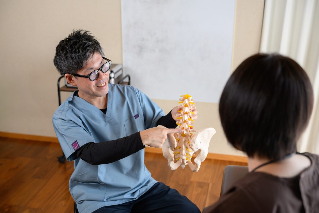 沼津市の接骨院で股関節の痛みの原因の説明を受ける女性